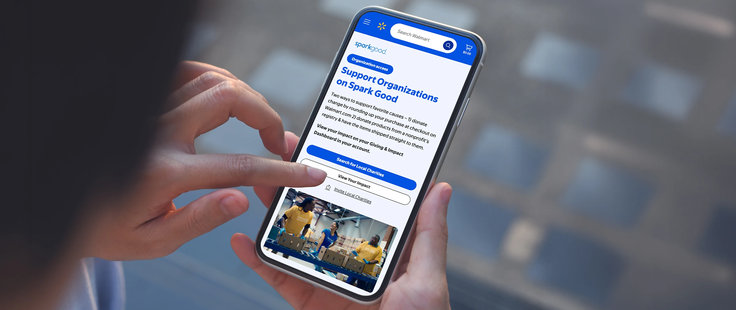 A person holds a smartphone and interacts with a donation or support application on the screen. The interface shows a section titled "Support Organizations on Spark Good" with blue buttons and text fields. The user’s finger is poised to tap a call-to-action button, suggesting online giving or charitable support. The background is softly blurred, keeping focus on the mobile device and the app interface.
