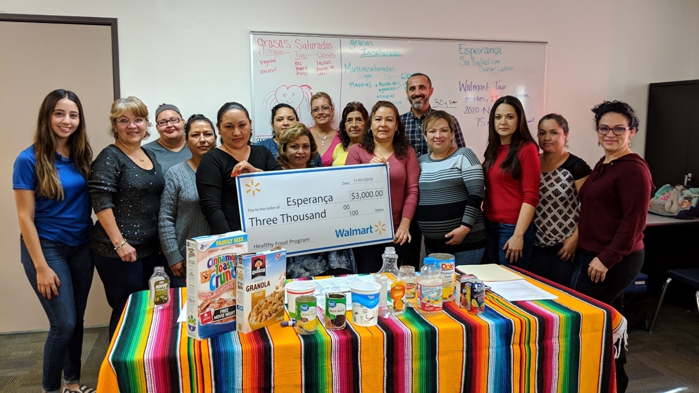 Group of people from local community receiving a grant of $3000 check from Walmart Foundation.